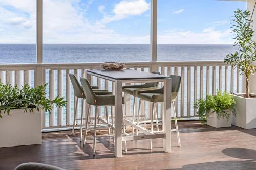 a table and chairs on a balcony with the ocean at PM78 Boutique Apartments in Willemstad