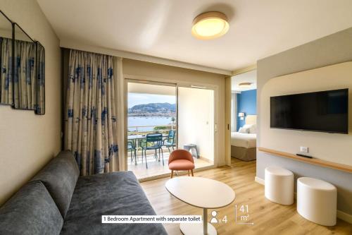 a living room with a couch and a view of the ocean at Best Western Plus Ajaccio Amirauté in Ajaccio