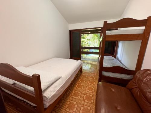 a bedroom with two bunk beds and a couch at Casa Una à Beira Rio - Barra do Una - 450m da praia in São Sebastião