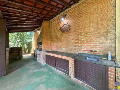 a brick kitchen with a sink and a brick wall at Casa Una à Beira Rio - Barra do Una - 450m da praia in São Sebastião