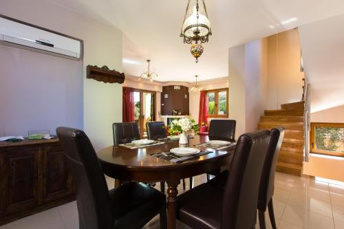 a dining room with a wooden table and black chairs at Villa Sia in Adelianos Kampos