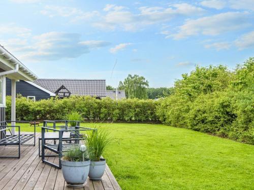 a backyard with a deck with a lawn at 6 person holiday home in Juelsminde-By Traum in Sønderby