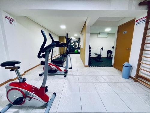 a gym with two exercise bikes in a room at Apto 6º andar, 200m praia, 15min Beto Carrero, 2 quartos, sacada com churrasqueira in Piçarras