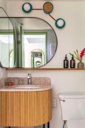 a bathroom with a sink and a mirror at Wayfinder Waikiki - Voted Top 10 Best Hotels in Hawaii! in Honolulu