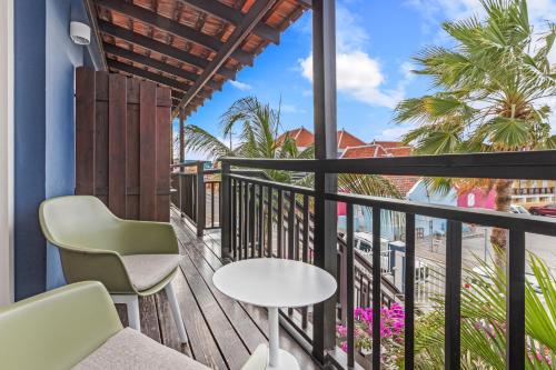 a balcony with a table and chairs and a view of the beach at PM78 Boutique Apartments in Willemstad