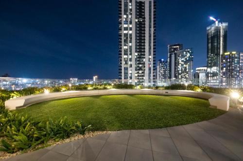 a large grassy area with a city skyline at night at Tammex Luxury Properties - Melbourne Square in Melbourne