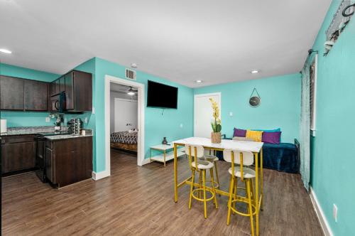 a kitchen and living room with blue walls and a table at 1BR Apt with Fully Equipped Kitchen Close to Major Attractions in Houston