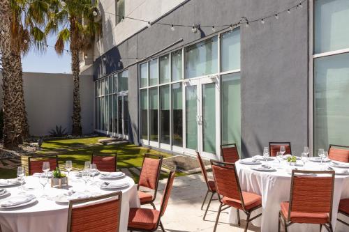 a patio with tables and chairs and a building at Courtyard by Marriott Hermosillo in Hermosillo