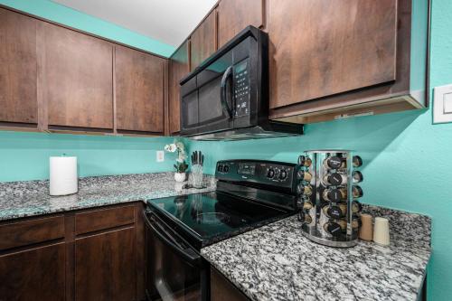 a kitchen with a stove and a microwave at 1BR Apt with Fully Equipped Kitchen Close to Major Attractions in Houston