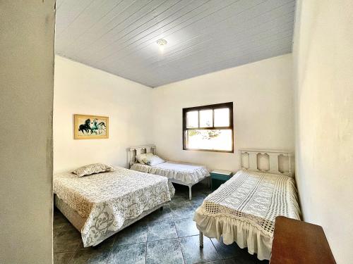 a bedroom with two beds and a window at Casa de Campo Terra da Paz in Itatiba