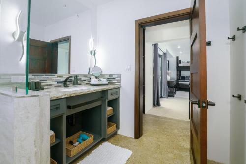 un bagno con lavandino e specchio di Spacious 4-Bed Villa in Placencia Village w Pool a Placencia