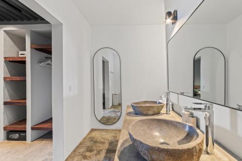 a bathroom with two sinks and two mirrors at PM78 Boutique Apartments in Willemstad