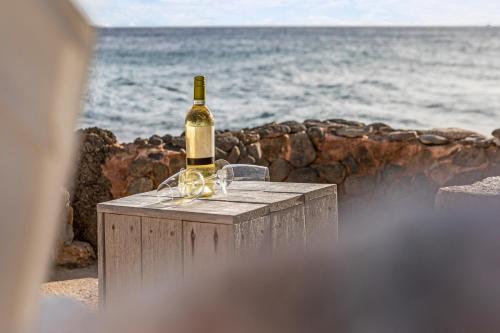 a bottle of wine sitting on a table next to the ocean at PM78 Boutique Apartments in Willemstad