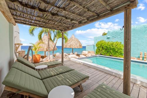 a patio with chairs and a swimming pool at PM78 Boutique Apartments in Willemstad