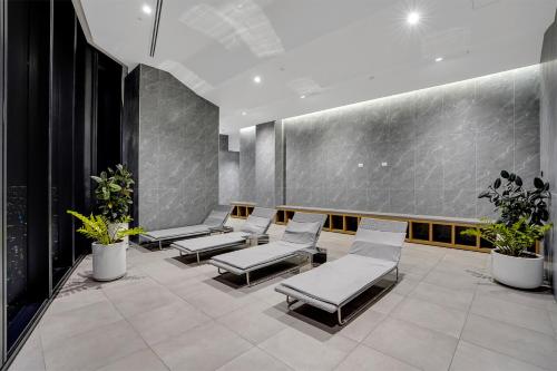a waiting area with chairs and plants in a building at Tammex Luxury Properties - Melbourne Square in Melbourne