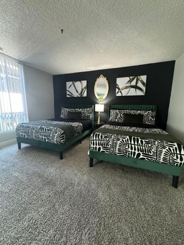 a bedroom with two beds and a mirror on the wall at Hollywood Apartments Mario & No Themed With Pool FREE parking and WIFI in Los Angeles