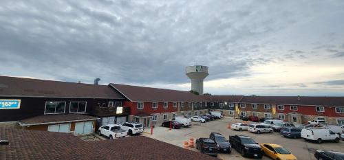 a parking lot in front of a building with a water tower at Rodeway Inn in West Fargo