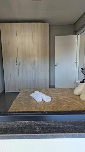 a room with two towels on a bed with a door at Flat Diamond 908 in São Lourenço