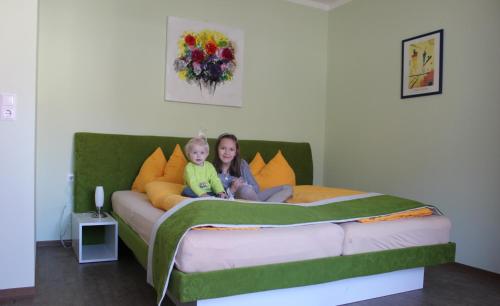 a woman and a child sitting on a bed at Gasthof zum Mohrn in Oberwölz Stadt