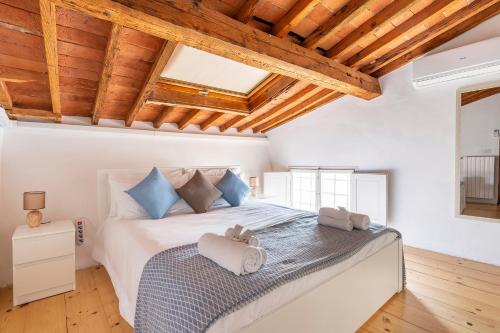 a bedroom with a large white bed with blue pillows at [Piazza Santo Spirito] Appartamento con 2 Camere Matrimoniali in Florence