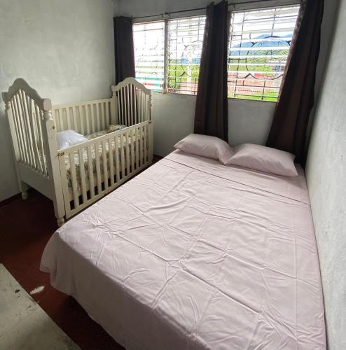 a bedroom with two cribs and a large white bed at Casa Juayúa in Juayúa