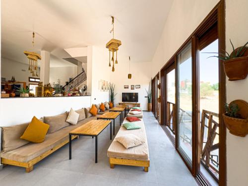a living room with couches and tables at Sun House Morocco in Taghazout