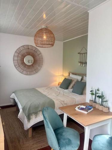 a bedroom with a bed and a table and a chair at Grand large Appartement terrasse front de mer Barcarès in Le Barcarès