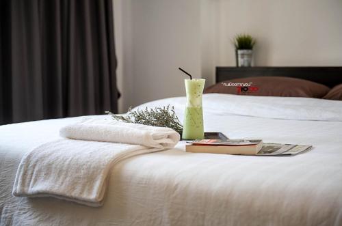 a white bed with two towels and a vase on it at U Dee Room and Coffee in Kanchanaburi