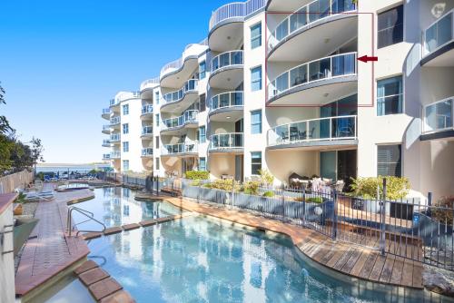 a swimming pool in front of a building at 3 Bedroom Apartment with Lift in Caloundra