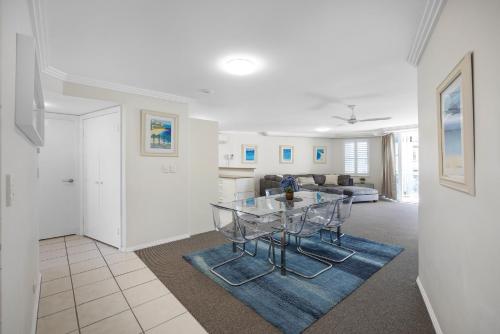 a dining room and living room with a glass table at 3 Bedroom Apartment with Lift in Caloundra