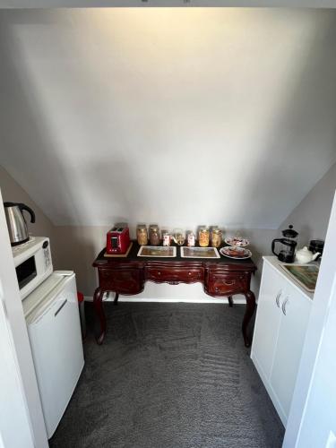 a small kitchen with a wooden table in a room at Tudor Manor Bed & Breakfast in Paraparaumu Beach