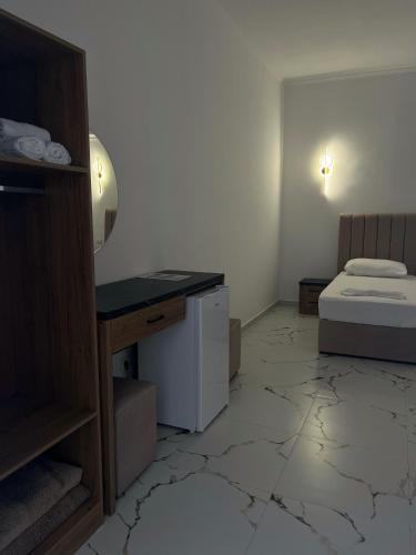 a room with a bed and a desk in a room at Xhefri's Apartments in Vlorë