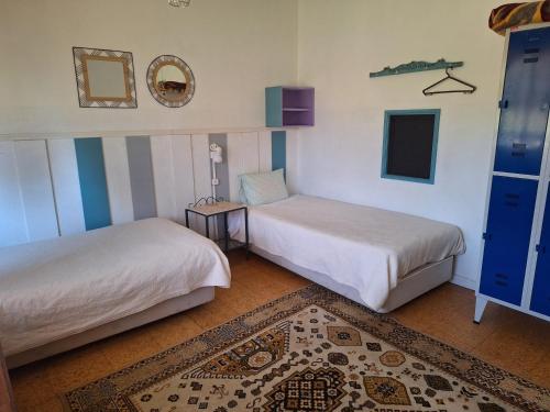 a room with two beds and a rug at Villa Margarida in Viana do Castelo