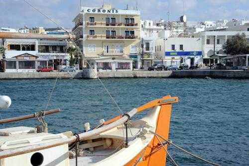 a boat in the water with buildings in the background at Hotel Coronis in Naxos Chora