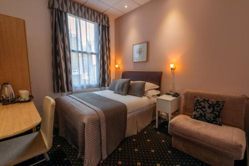 a hotel room with a bed and a chair at The Melita in London