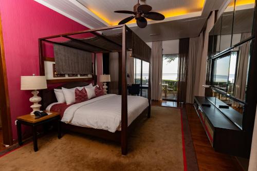 a bedroom with a bed and a ceiling fan at Ombak Villa Langkawi in Pantai Cenang