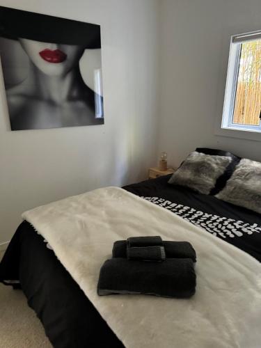 a bed with a black towel on top of it at Luxurious Kiwiana Raumati Beachfront Home in Paraparaumu