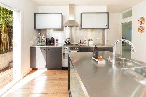 a kitchen with a sink and a counter top at Luxurious Kiwiana Raumati Beachfront Home in Paraparaumu