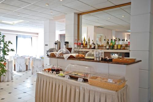 a restaurant with a counter with food and drinks at Hotel Coronis in Naxos Chora