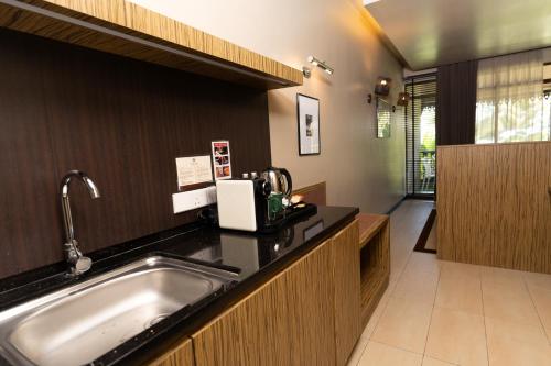 a kitchen with a sink and a counter at Ombak Villa Langkawi in Pantai Cenang