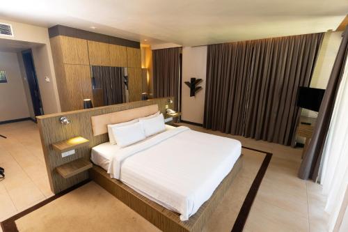 a bedroom with a large white bed in a room at Ombak Villa Langkawi in Pantai Cenang