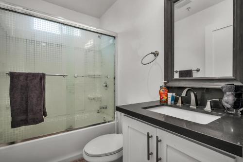 a bathroom with a sink and a toilet and a mirror at Stylish One-Bedroom Retreat with Central AC & Free Parking in the Heart of Hollywood in Los Angeles