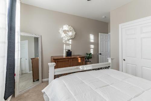 a bedroom with a white bed and a mirror at Modern 4BR Oasis, Fireplace, Patio & Spacious Family Room in Palmdale