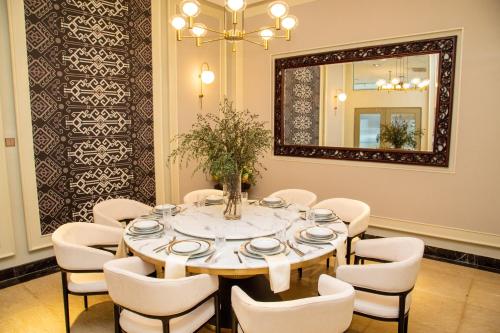 a dining room with a table and chairs and a mirror at Ombak Villa Langkawi in Pantai Cenang
