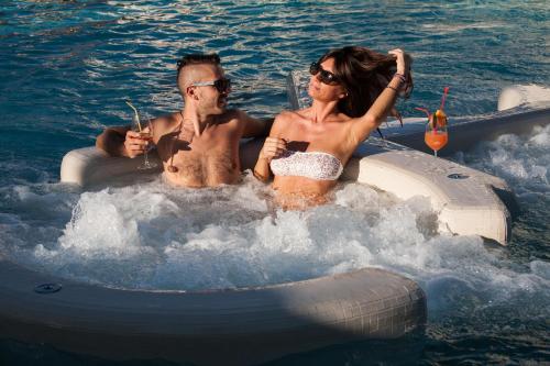 a man and a woman riding on an inflatable boat in the water at Hotel Terme Abano Verdi in Abano Terme