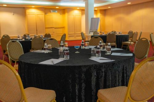 a conference room with a black table with chairs at Ombak Villa Langkawi in Pantai Cenang