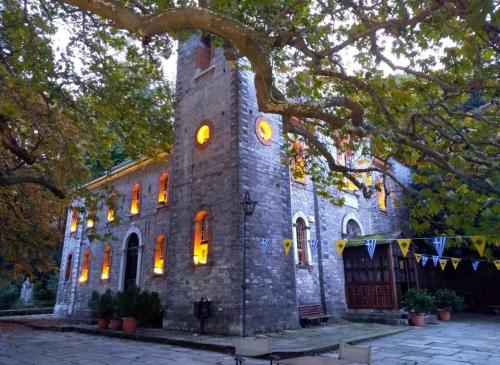 an old stone church with lights in the windows at Villa Zina in Pelion in Agios Dimitrios