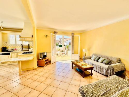 un soggiorno con un divano e un tavolo di Canet plage Maison de vacances 2 Chambres et jardin a Canet-en-Roussillon