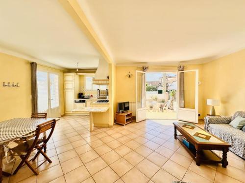 un ampio soggiorno con tavolo e divano di Canet plage Maison de vacances 2 Chambres et jardin a Canet-en-Roussillon