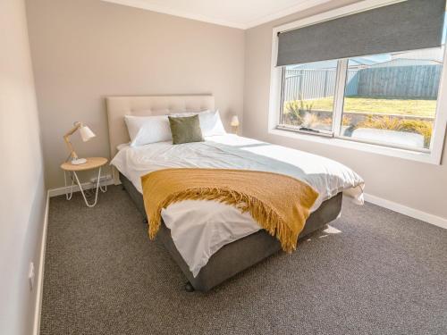 a bedroom with a large bed and a window at Coastal Bliss Retreat Elegant Beachside Escape at Hawley Beach in Port Sorell